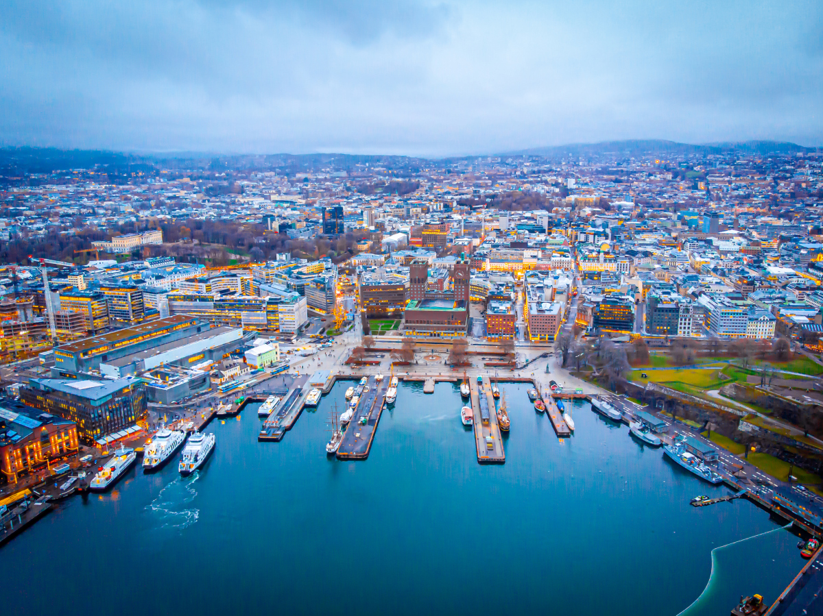 Oslo sett i fugleperspektiv. Bildet er tatt fra luften over vannet ved Oslo Rådhus. På bildet kan vi se tusenvis av tusenvis av boliger og bygg i Oslo. Foto
