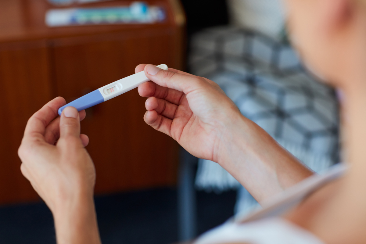 En kvinne sjekker resultatet på graviditetstesten hun har tatt. Foto